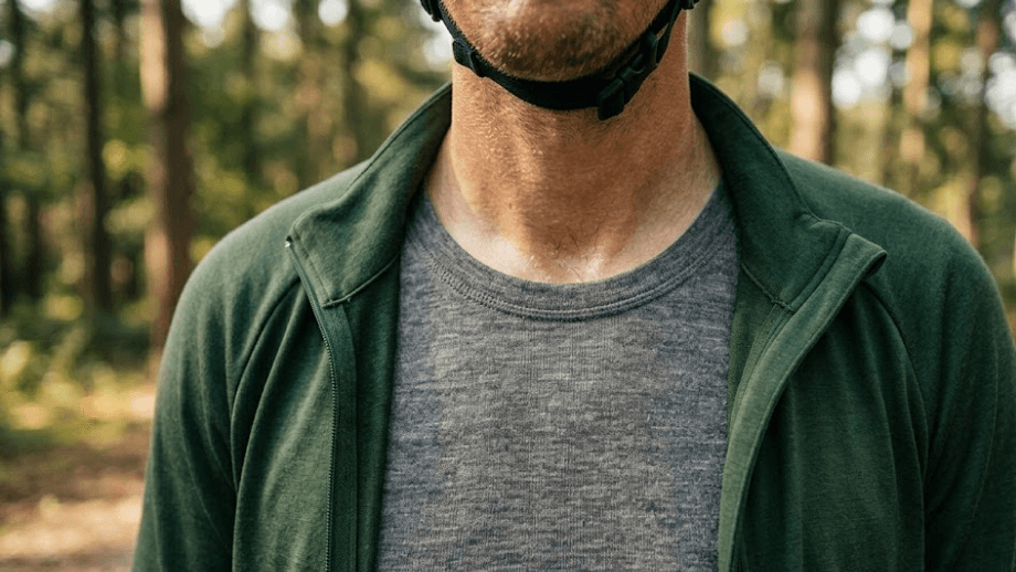 Close-up van een fietser met een half open geritst shirt, waardoor het merinowol ondershirt zichtbaar is. Dit is de belangrijkste stap in een goed laagjessysteem fietskleding.