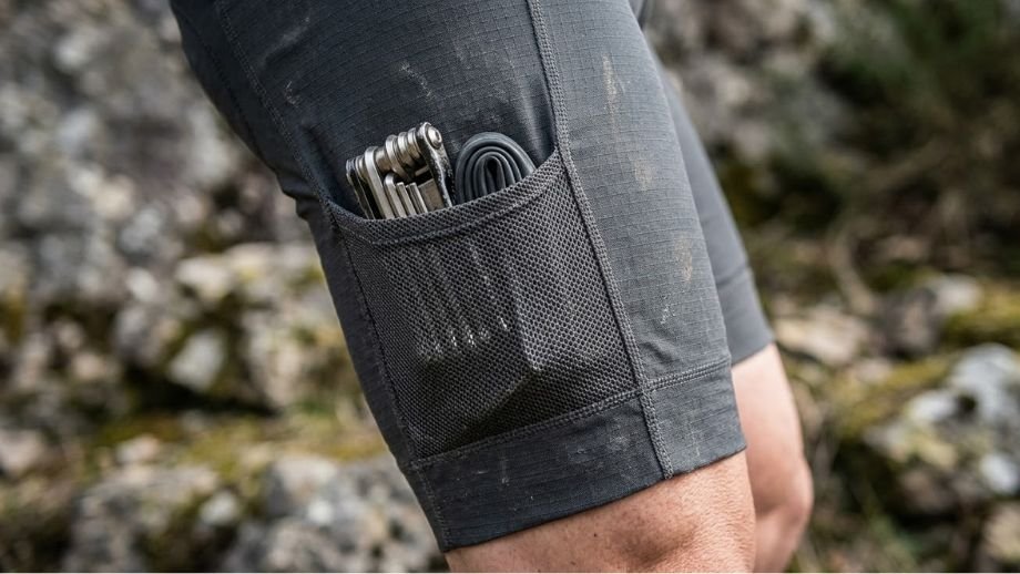 gedetailleerde macro-opname van de robuuste en slijtvaste stof van een fietsbroek met zakken voor gravelbiken in rotsachtig terrein