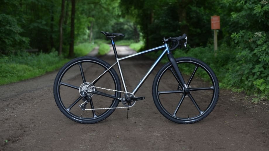 UNpaved Cycles Vedder32 custom titanium gravelbike met 6-spaaks wielen op bospad