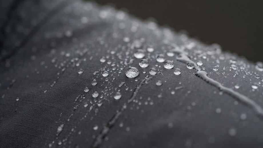 waterdicht of waterafstotend regenjack gravel waterdruppels afparelen DWR coating close-up gravelbike
